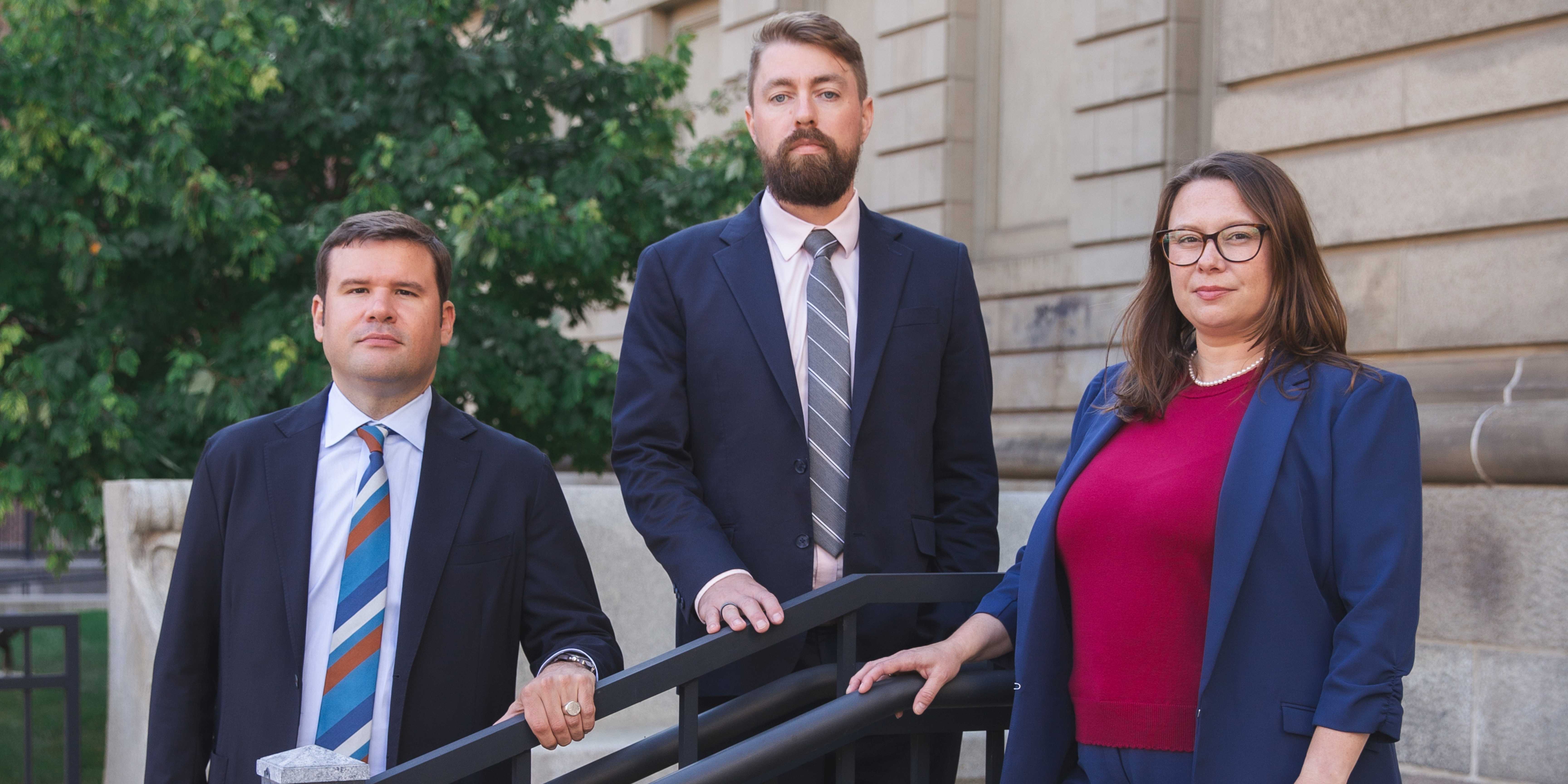 The three lawyers outside courtroom banner Oct 2025 (1)